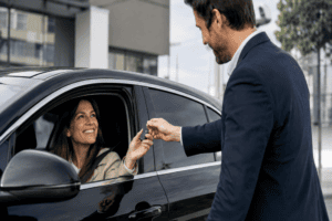 Conductora recibiendo las llaves de uno de los coches eléctricos baratos disponibles en España